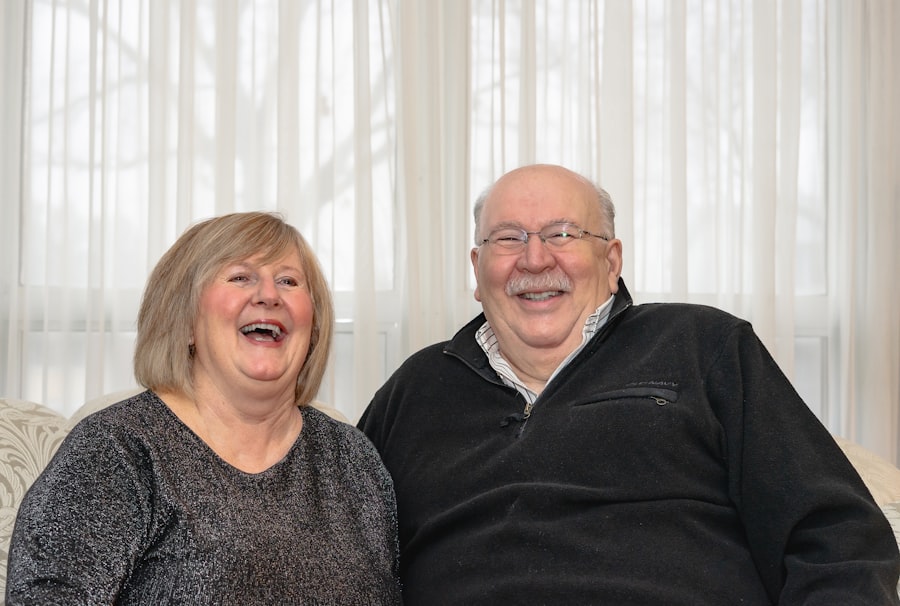 An older couple laughing together on their sofa